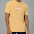 Man wearing a gold t-shirt with 'Humble Sundays' text