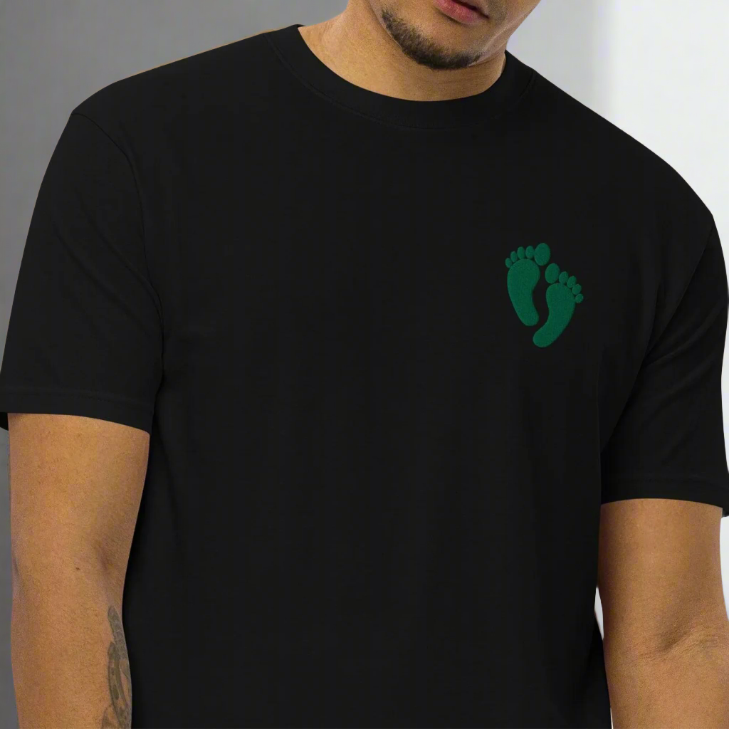 PJ green feet design embroidered into the lest chest of a t-shirt.