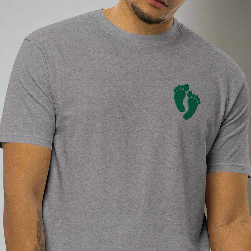 PJ green feet design embroidered into the lest chest of a t-shirt.