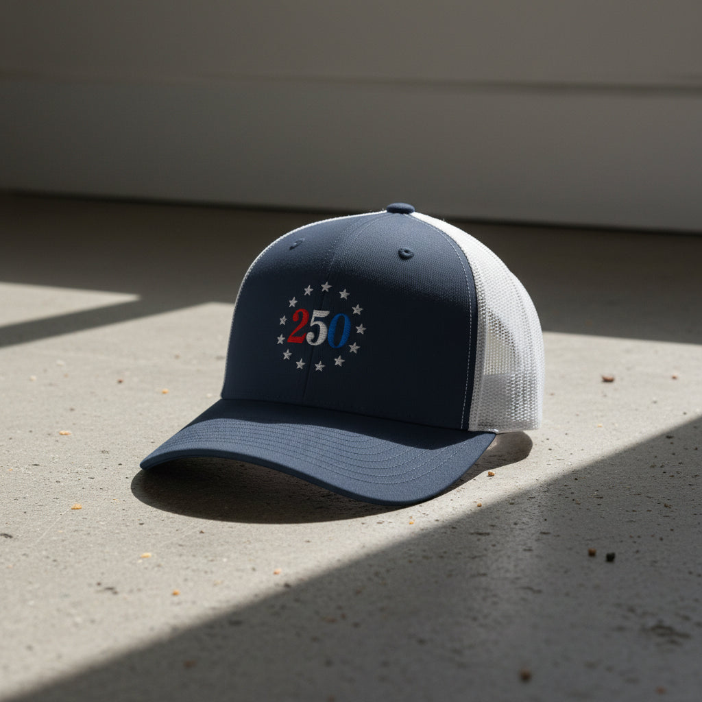 navy and white trucker hat with embroidered "250" inside a circle of stars for america 250th anniversary and 4th of july