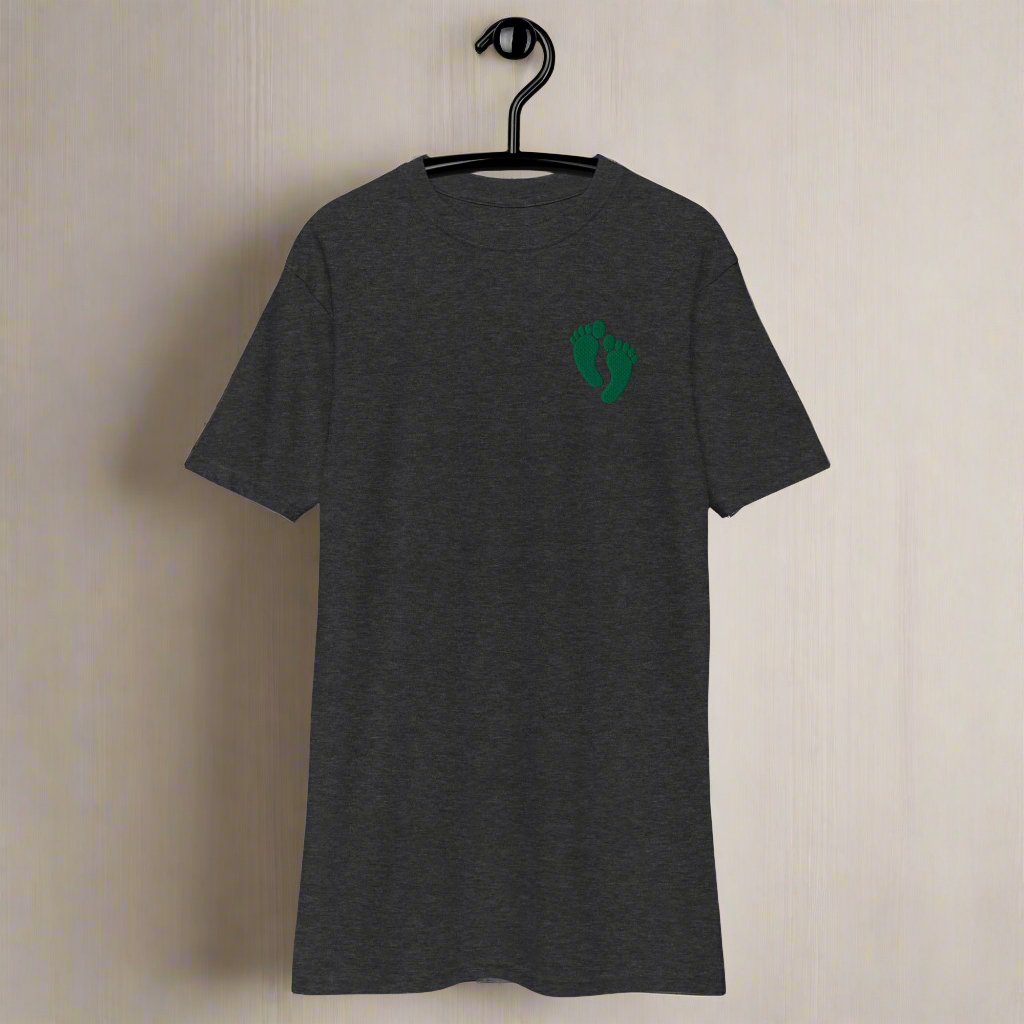 PJ green feet design embroidered into the lest chest of a t-shirt.