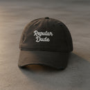 black distressed dad hat embroidered with the words regular dude