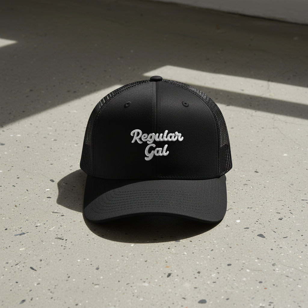 black snapback cap with embroidered 'Regular Gal' text 